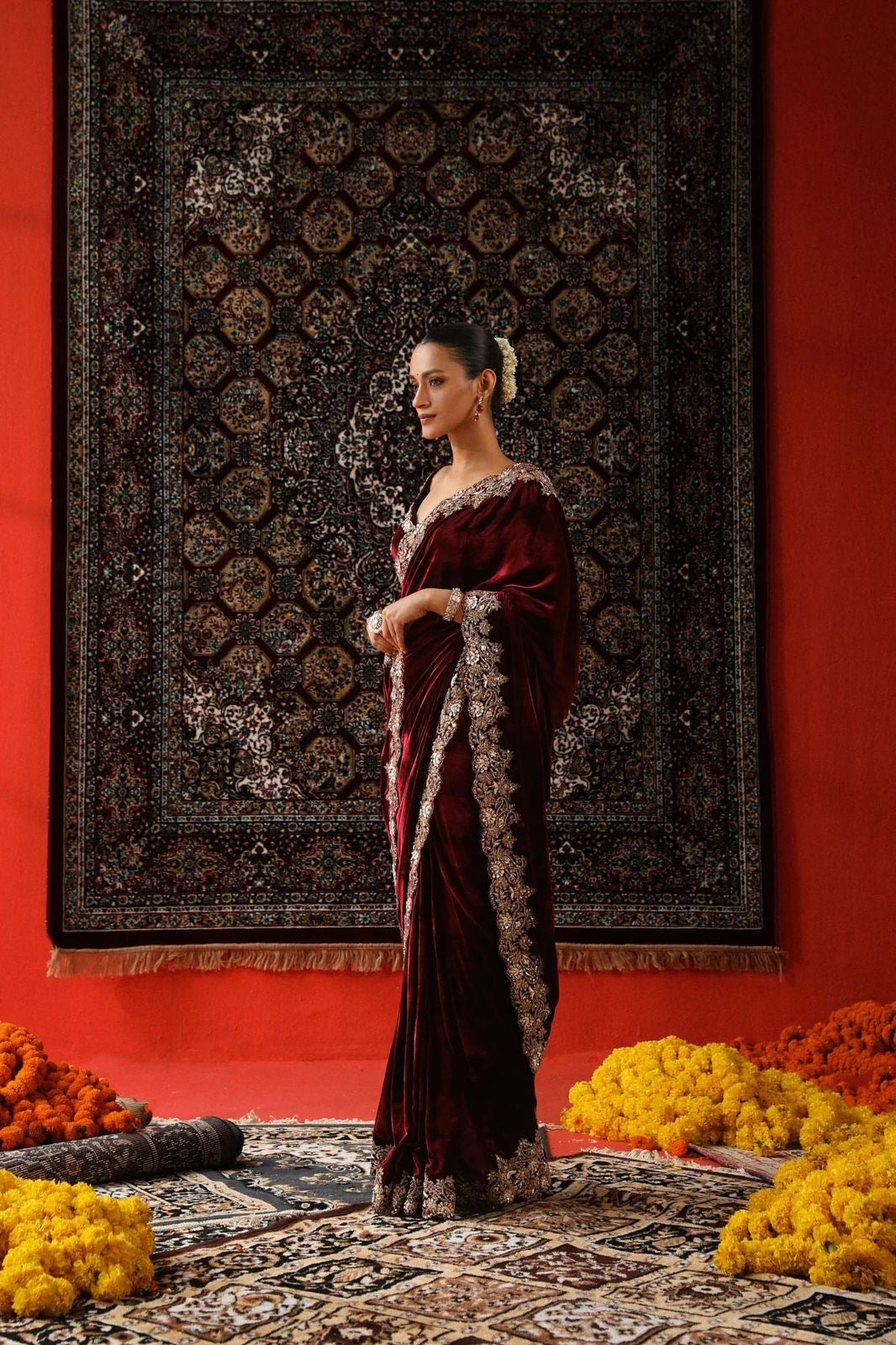 "Radiant Elegance: This deep maroon velvet saree, embellished with exquisite golden embroidery, exudes regality and charm, perfect for grand celebrations."
