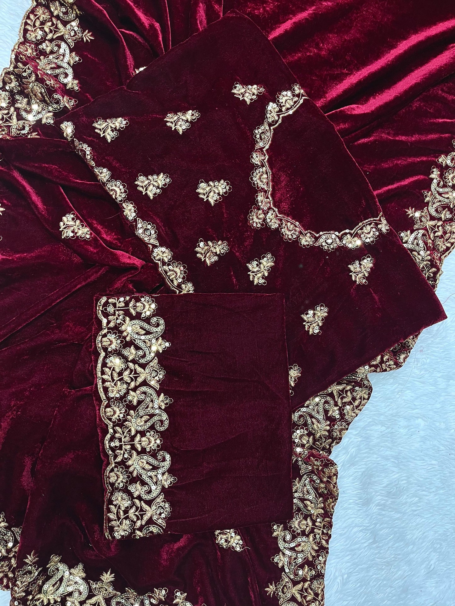 "Radiant Elegance: This deep maroon velvet saree, embellished with exquisite golden embroidery, exudes regality and charm, perfect for grand celebrations."