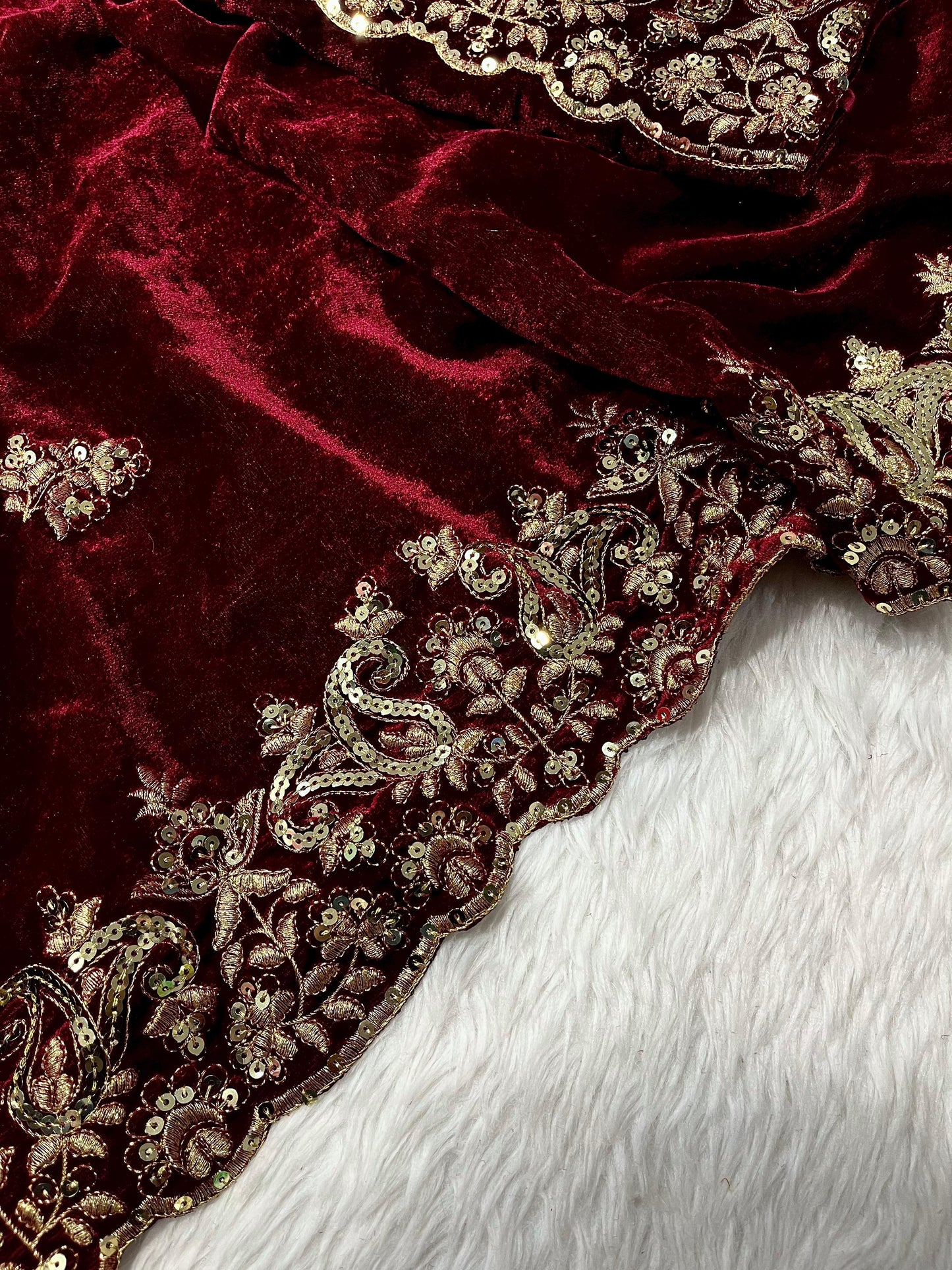 "Radiant Elegance: This deep maroon velvet saree, embellished with exquisite golden embroidery, exudes regality and charm, perfect for grand celebrations."