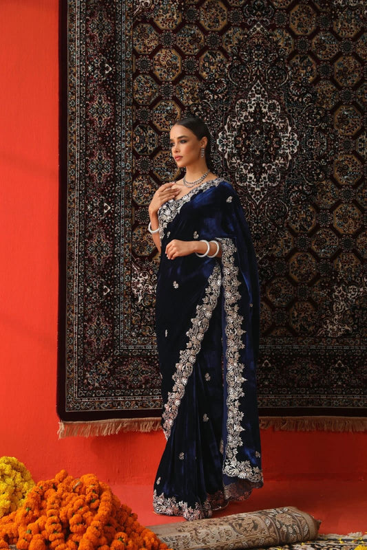 "Elegance Redefined: This royal blue velvet saree adorned with intricate silver embroidery is the epitome of timeless grace and sophistication."
